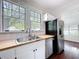 A sunlit kitchen features a stainless steel refrigerator, undermount sink, and butcher block countertops at 606 N Merrin St, Plant City, FL 33563