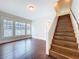 Bright living room featuring hardwood floors, large windows, and staircase with wood steps at 606 N Merrin St, Plant City, FL 33563