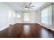 Sunlit living room boasts hardwood floors, white trim, sheer curtains and a bright, airy feel at 606 N Merrin St, Plant City, FL 33563
