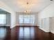 Sun-filled living room highlights hardwood floors, decorative lighting, and view of a painted brick fireplace at 606 N Merrin St, Plant City, FL 33563