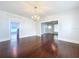 Spacious living room showcases hardwood floors, modern chandelier, and open layout to adjacent rooms at 606 N Merrin St, Plant City, FL 33563