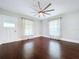 Bright living room featuring dark hardwood floors, white walls and trim, and natural light from multiple windows at 606 N Merrin St, Plant City, FL 33563