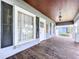 Inviting front porch with wood flooring, decorative hanging light, and a view of the neighborhood at 606 N Merrin St, Plant City, FL 33563