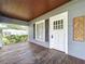 Charming covered porch with wood decking, a classic entry door, and detailed wood trim at 606 N Merrin St, Plant City, FL 33563