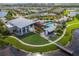 Aerial view of the community clubhouse, pool, and surrounding landscape with lakes and houses nearby at 6331 Voyagers Pl, Apollo Beach, FL 33572