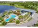 Aerial view of the community clubhouse, swimming pool, and lakes and gardens surrounding the building at 6331 Voyagers Pl, Apollo Beach, FL 33572