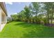 Lush backyard with well-maintained lawn, mature trees, and a private fence at 6331 Voyagers Pl, Apollo Beach, FL 33572
