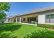 Well-maintained backyard featuring a covered patio, lush lawn, and privacy hedges at 6331 Voyagers Pl, Apollo Beach, FL 33572