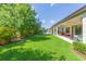 Expansive backyard with green lawn, covered patio, and partial view of neighborhood pool at 6331 Voyagers Pl, Apollo Beach, FL 33572