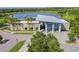 Aerial view of the community clubhouse and parking lot, surrounded by mature landscaping and a lake at 6331 Voyagers Pl, Apollo Beach, FL 33572