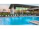 Community pool with fountain, lounge chairs, and umbrellas, adjacent to a building with glass facade at 6331 Voyagers Pl, Apollo Beach, FL 33572