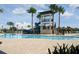 View of community pool with a water slide, lounge chairs, and mature palms at 6331 Voyagers Pl, Apollo Beach, FL 33572