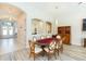 Elegant dining room featuring a wood table, arched doorways, wood-look flooring, and decorative lighting at 6331 Voyagers Pl, Apollo Beach, FL 33572