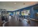 The community fitness center features modern exercise equipment, TV screens and bright window views at 6331 Voyagers Pl, Apollo Beach, FL 33572