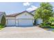 Charming home featuring a three-car garage and brick-paved driveway, complemented by well-maintained landscaping at 6331 Voyagers Pl, Apollo Beach, FL 33572