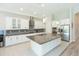 Bright, modern kitchen featuring a large island, stainless steel appliances, and elegant pendant lighting fixtures at 6331 Voyagers Pl, Apollo Beach, FL 33572