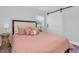 Bright bedroom featuring a plush bed with soft, pink bedding and a modern sliding barn door at 6511 10Th N St, St Petersburg, FL 33702