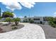 Charming single-story home featuring a circular driveway, palm trees, and a freshly landscaped front yard at 6511 10Th N St, St Petersburg, FL 33702