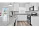 Well-lit kitchen with granite counters, stainless steel appliances, and white cabinets for a sleek design at 6511 10Th N St, St Petersburg, FL 33702