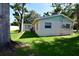 The backyard features a well-maintained lawn, surrounded by trees, providing a serene and private outdoor space at 7684 Oakhurst Rd, Seminole, FL 33776