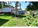 Spacious backyard featuring a well-maintained lawn, mature trees, and a shed, providing ample outdoor space at 7684 Oakhurst Rd, Seminole, FL 33776