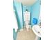 Compact bathroom with a toilet, a cabinet overhead, and a pedestal sink in a calming light blue at 7684 Oakhurst Rd, Seminole, FL 33776