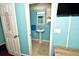 Bathroom with light blue walls, a pedestal sink, a wall mirror, and white trim for a clean and refreshing look at 7684 Oakhurst Rd, Seminole, FL 33776