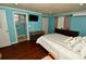 Bedroom featuring wood floors, a bed, an adjacent bathroom and a flat-screen TV in a calming and relaxing setting at 7684 Oakhurst Rd, Seminole, FL 33776