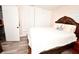 Comfortable bedroom with wood-look floors, a decorative bedframe, and ample closet space at 7684 Oakhurst Rd, Seminole, FL 33776