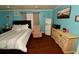 Charming bedroom with wood floors, a comfortable armchair, a vintage refrigerator, and coastal-themed decor at 7684 Oakhurst Rd, Seminole, FL 33776