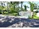 Charming home with well-manicured landscaping, lush trees, and a secure wrought iron fence, enhancing its curb appeal at 7684 Oakhurst Rd, Seminole, FL 33776