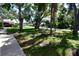Spacious front yard with mature trees and lush green lawn, complemented by a sidewalk at 7684 Oakhurst Rd, Seminole, FL 33776