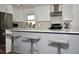 Modern kitchen featuring white cabinets, stainless steel appliances, and a breakfast bar with stylish seating at 7684 Oakhurst Rd, Seminole, FL 33776