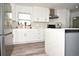 Modern kitchen features stainless steel appliances, sleek white cabinetry, and a large marble countertop island at 7684 Oakhurst Rd, Seminole, FL 33776