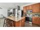 Open kitchen with stainless steel appliances and wooden cabinets connecting to living area at 9329 Wellstone Dr, Land O Lakes, FL 34638
