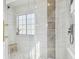 Modern walk-in shower with white and gray tile, rain shower head, and built-in niche at 9329 Wellstone Dr, Land O Lakes, FL 34638