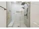 Modern shower with white and gray tile, rain shower heads, a shower bench, and gold accents at 9329 Wellstone Dr, Land O Lakes, FL 34638