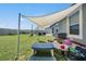 Backyard with a shade cover, patio, and a play area in a lush, green setting at 9839 Lemon Drop Loop, Sun City Center, FL 33573