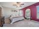 Relaxing bedroom featuring a queen bed, accent wall, and large mirror at 9839 Lemon Drop Loop, Sun City Center, FL 33573