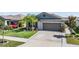 Well-maintained single-Gathering home with a manicured lawn, two-car garage, and attractive landscaping at 9839 Lemon Drop Loop, Sun City Center, FL 33573