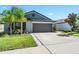 Single-story home with a two-car garage, landscaped yard, and a well-maintained lawn at 9839 Lemon Drop Loop, Sun City Center, FL 33573