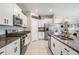 Kitchen featuring granite countertops, stainless steel appliances, and a view into living space at 9839 Lemon Drop Loop, Sun City Center, FL 33573