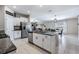 Well-equipped kitchen island with white cabinets, granite countertops, and stainless steel appliances offers seamless flow to dining at 9839 Lemon Drop Loop, Sun City Center, FL 33573