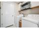 Functional laundry room with modern washer and dryer, and storage shelves at 9839 Lemon Drop Loop, Sun City Center, FL 33573