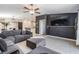 Open living space featuring a gray sectional, TV wall feature, with sightlines to dining and kitchen at 9839 Lemon Drop Loop, Sun City Center, FL 33573