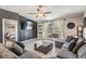 Cozy living room with gray sectional, TV wall feature, and access to outdoor patio at 9839 Lemon Drop Loop, Sun City Center, FL 33573