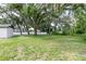 Exterior view of home with a view of green grass, mature trees and a white fence at 1008 Shangri La Dr, Seffner, FL 33584