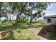 View of home's backyard with a well maintained lawn, mature trees and bright blue skies at 1008 Shangri La Dr, Seffner, FL 33584