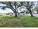 Exterior view of home with lush green grass and shade from mature trees at 1008 Shangri La Dr, Seffner, FL 33584
