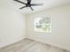 This bedroom features light, neutral walls, light wood-look floors and a large window at 1008 Shangri La Dr, Seffner, FL 33584